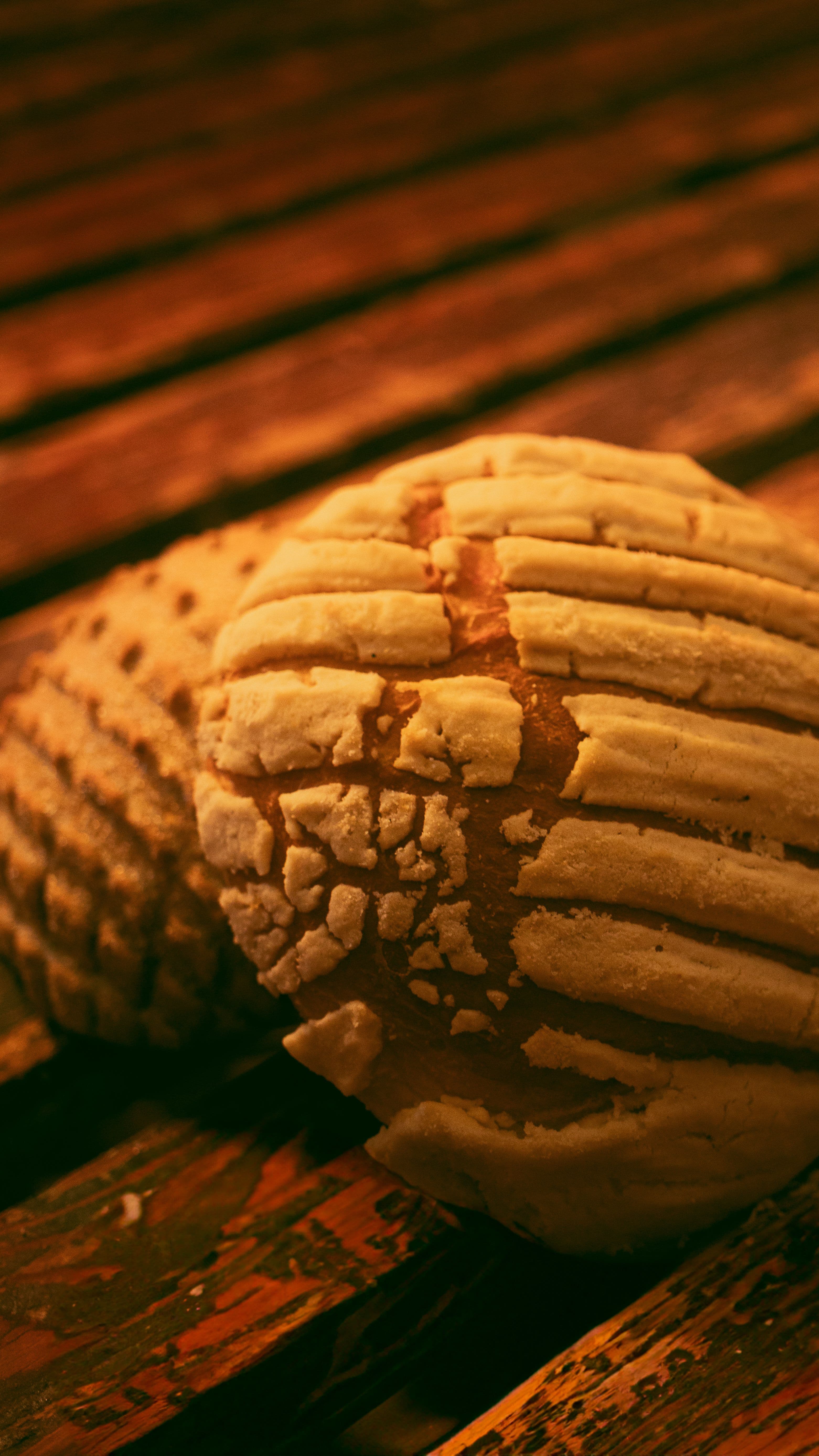 Freshly baked conchas, a classic Mexican sweet bread, on a rustic wooden table at Mi Pueblo Panadería